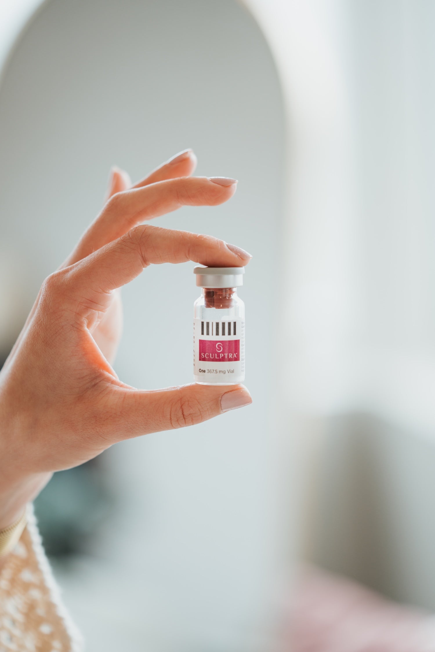 Hand holding a vial of Sculptra in a bright treatment space at Bloom Aesthetics in Spokane