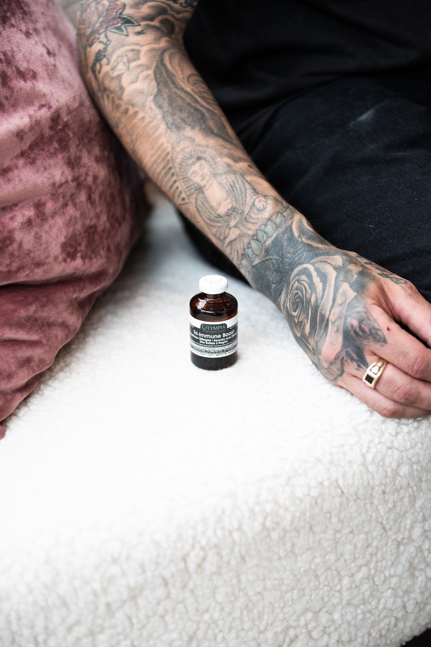 Arm with bottle of Olympa Tri-Immune boost for vitamin injections available at Bloom Aesthetics medspa in Spokane