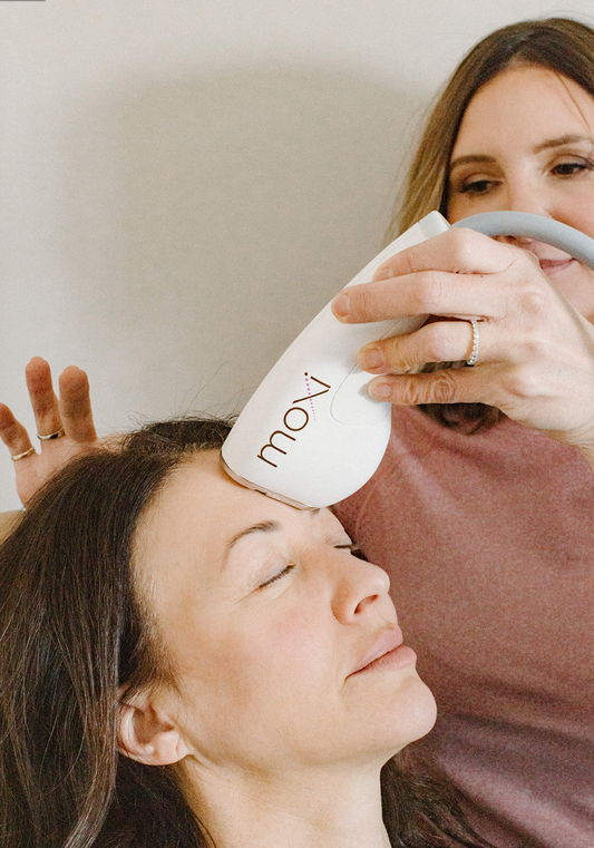Nurse practitioner using Moxi laser treatment on a woman's forehead to target to sun damage, uneven tone, dullness, and early signs of aging at Bloom Aesthetics